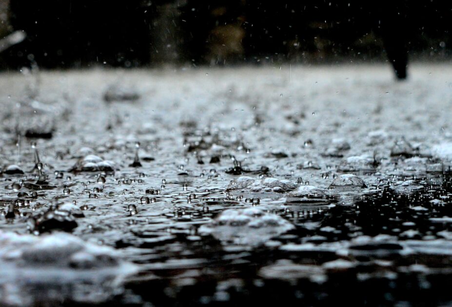 雨粒が落ちて地面が水で埋まっている写真